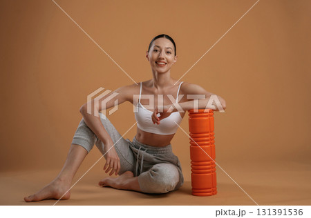 On the floor, sitting. Beautiful fitness woman is in the studio 131391536