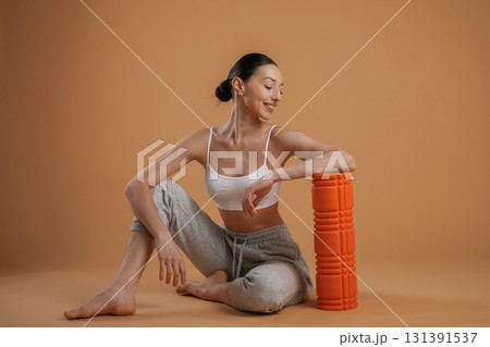 On the floor, sitting. Beautiful fitness woman is in the studio 131391537
