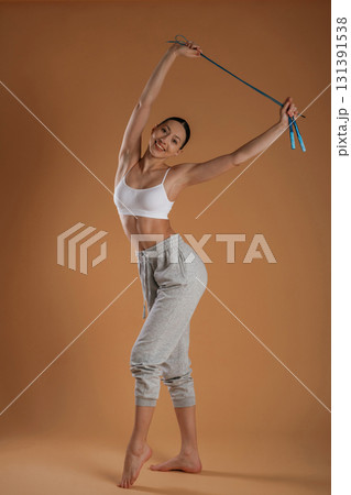 Jumping rope is in hands. Beautiful fitness woman is in the studio Jumping rope is in hands. Beautiful fitness woman is in the studio 131391538