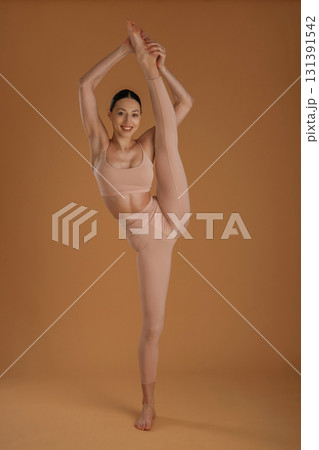 Leg is high up, good stretching. Beautiful fitness woman is in the studio 131391542