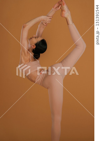 Leg is high up, good stretching. Beautiful fitness woman is in the studio 131391544