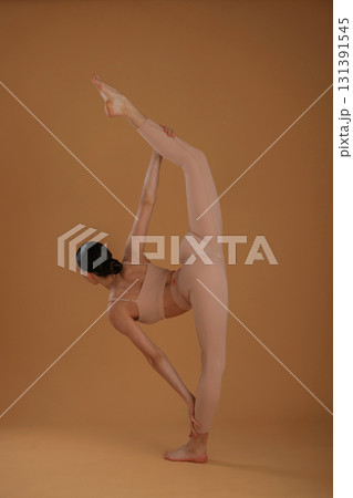 Side view, doing exercise for legs and hands. Beautiful fitness woman is in the studio Side view, doing exercise for legs and hands. Beautiful fitness woman is in the studio 131391545
