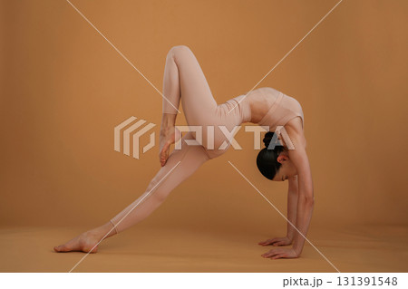 Flexible exercises. Beautiful fitness woman is in the studio 131391548