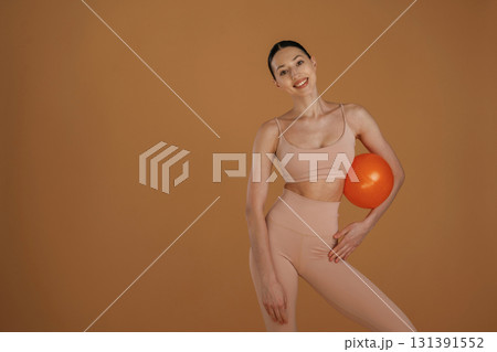 With red ball. Beautiful fitness woman is in the studio 131391552