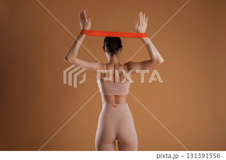 Cloth for stretching hands. Beautiful fitness woman is in the studio 131391556