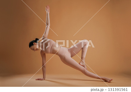 Flexible exercises. Beautiful fitness woman is in the studio Flexible exercises. Beautiful fitness woman is in the studio 131391561