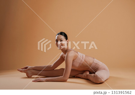 On the floor, sitting. Beautiful fitness woman is in the studio On the floor, sitting. Beautiful fitness woman is in the studio 131391562