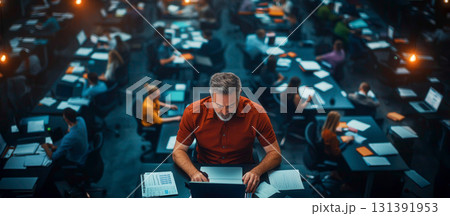Focused Man Working on Laptop in Busy Office Environment with Many Employees 131391953