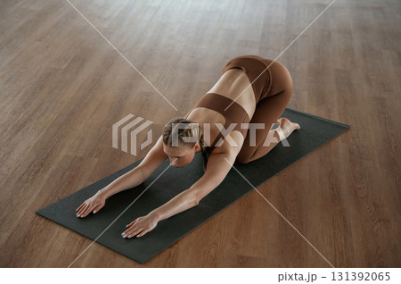 Spine exercise. Fitness woman in sportswear is indoors Spine exercise. Fitness woman in sportswear is indoors 131392065