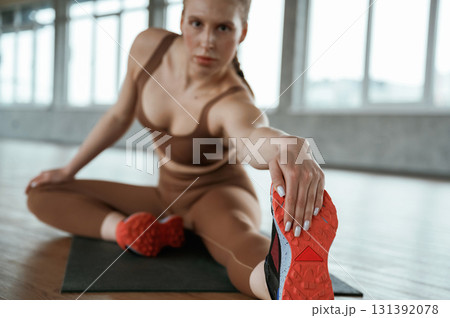 Stretching the legs. Fitness woman in sportswear is indoors Stretching the legs. Fitness woman in sportswear is indoors 131392078