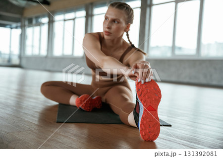 Stretching the legs. Fitness woman in sportswear is indoors Stretching the legs. Fitness woman in sportswear is indoors 131392081