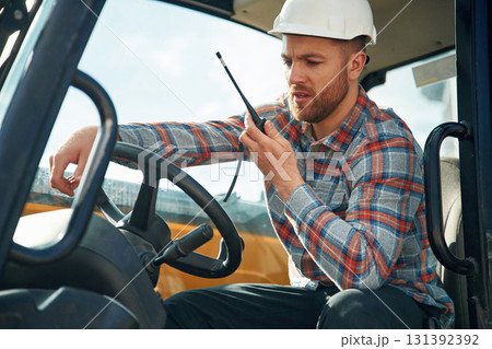 Using radio, talking. Man is with tractor. Agricultural worker Using radio, talking. Man is with tractor. Agricultural worker 131392392