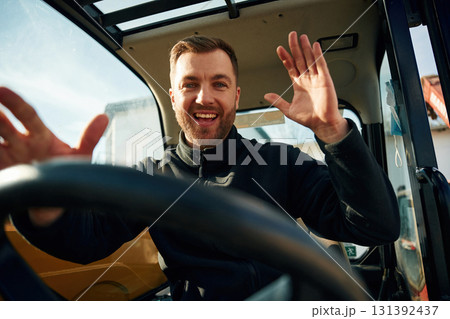 By the steering wheel. Man is with tractor. Agricultural worker By the steering wheel. Man is with tractor. Agricultural worker 131392437