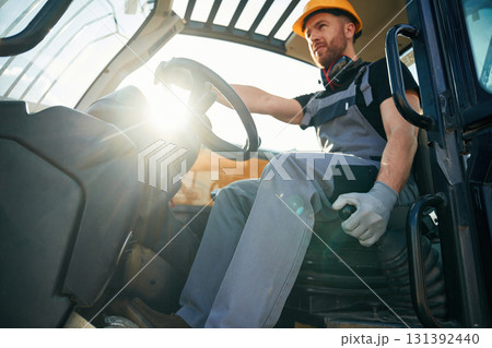 Sitting in the vehicle. Man is with tractor. Agricultural worker Sitting in the vehicle. Man is with tractor. Agricultural worker 131392440