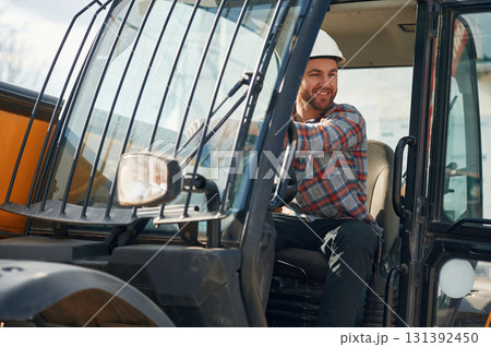 Happy driver. Man is with tractor. Agricultural worker Happy driver. Man is with tractor. Agricultural worker 131392450
