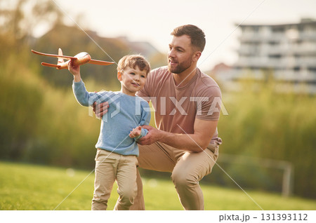 Freedom, playing with toy plane. Happy father with son are having fun on the field at summertime 131393112