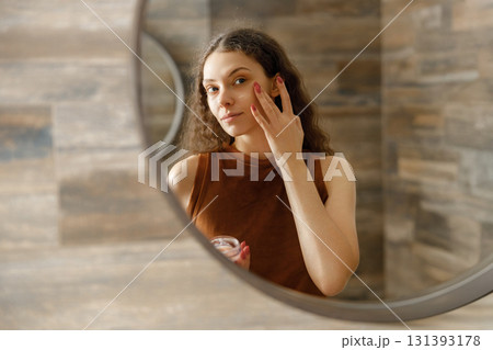 SelfCare Ritual Applying Cream in Front of the Mirror for Enhancing Your Beauty Routine 131393178
