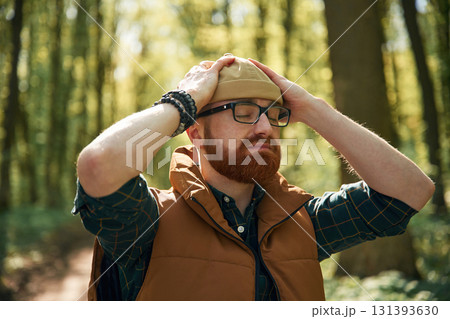 Wearing the hat. Bearded man is in the forest at daytime Wearing the hat. Bearded man is in the forest at daytime 131393630