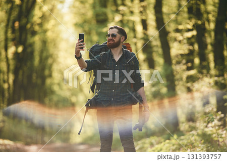 Colorful lens effect. Bearded man is in the forest at daytime Colorful lens effect. Bearded man is in the forest at daytime 131393757