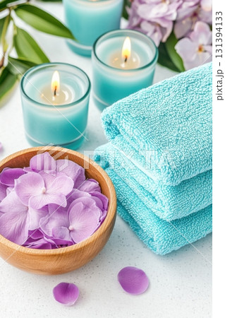 Relaxing wellness spa setup featuring turquoise towels, magenta flower petals, and calming blue candles for a serene atmosphere Relaxing wellness spa setup featuring turquoise towels, magenta flower petals, and calming blue candles for a serene atmosphere 131394133