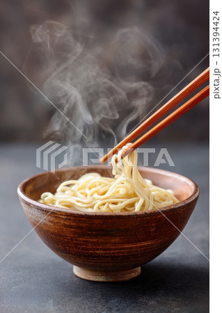 Soba noodles in rustic bowl with steam rising, captured in minimalist style, showcasing the delicate texture and warmth of this traditional dish with copy space 131394424