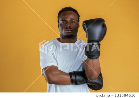 Professional boxer in gloves. Black guy is against yellow background 131394610