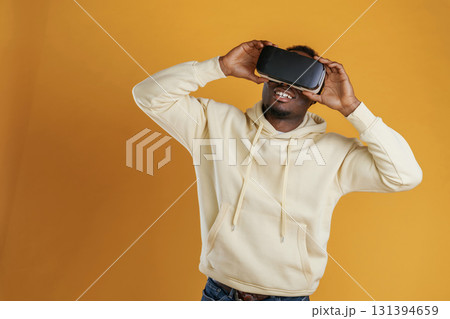 Virtual reality experience. Black guy is against yellow background Virtual reality experience. Black guy is against yellow background 131394659