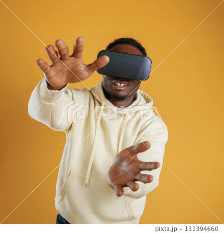 Virtual reality experience. Black guy is against yellow background Virtual reality experience. Black guy is against yellow background 131394660