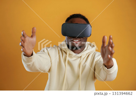 Virtual reality experience. Black guy is against yellow background Virtual reality experience. Black guy is against yellow background 131394662