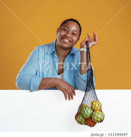 Fruits over white copy space. African American woman is in the studio against yellow background 131394697