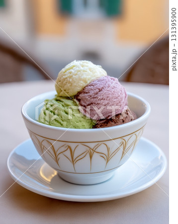 Savor four scoops of creamy Italian gelato in a charming bowl, surrounded by a quaint outdoor atmosphere filled with light 131395900