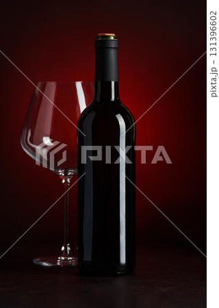 Wine Bottle and Empty Glass on Red and Black Gradient Background Wine Bottle and Empty Glass on Red and Black Gradient Background 131396602