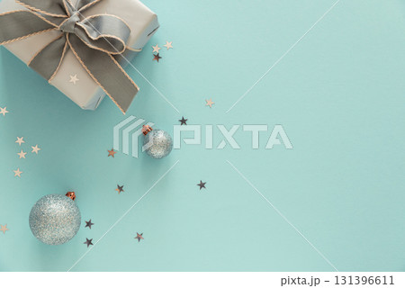 Silver Gift Box with Christmas Ornaments on Light Blue Background Silver Gift Box with Christmas Ornaments on Light Blue Background 131396611