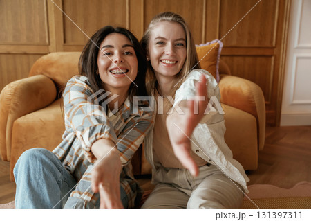 Having fun, sitting. Two happy young female best friends are indoors Having fun, sitting. Two happy young female best friends are indoors 131397311