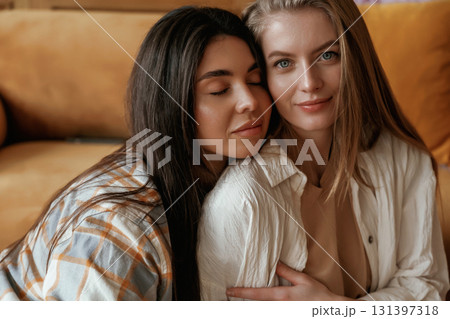 On the floor. On the shoulder of woman. Two happy young female best friends are indoors 131397318