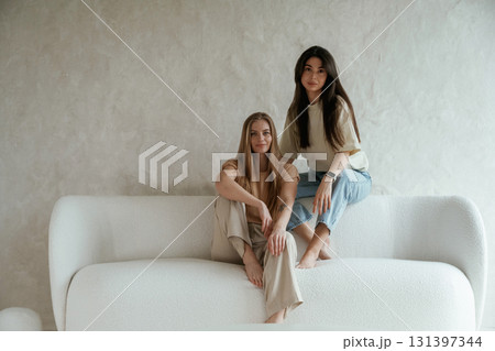 Looking forward, sitting. Two happy young female best friends are indoors 131397344