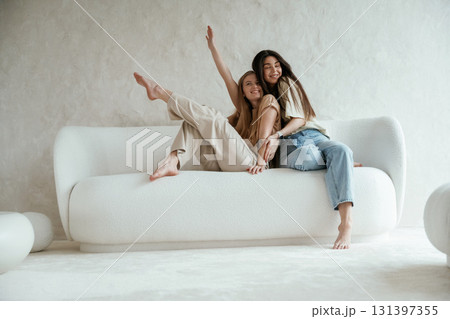 Looking forward, sitting. Two happy young female best friends are indoors 131397355