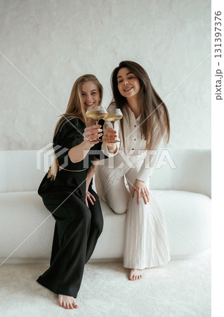 Event, with drinks, celebrating. Two happy young female best friends are indoors Event, with drinks, celebrating. Two happy young female best friends are indoors 131397376