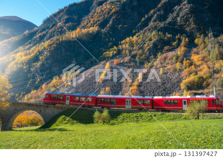 Aerial view of red Bernina Express train crossing a stone bridge Aerial view of red Bernina Express train crossing a stone bridge 131397427
