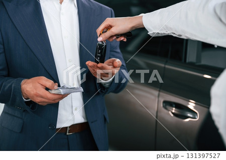 Close up view of woman giving keys of new car to the businessman Close up view of woman giving keys of new car to the businessman 131397527