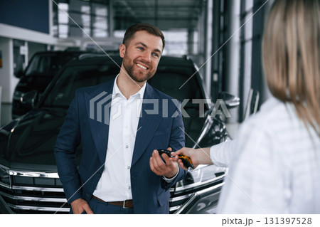 Businessman and woman are in a car dealership 131397528