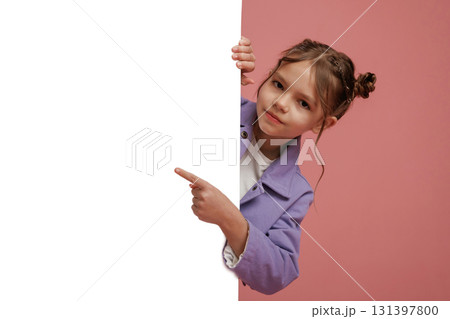 Showing at white copy space. Cute little girl is against pink background Showing at white copy space. Cute little girl is against pink background 131397800
