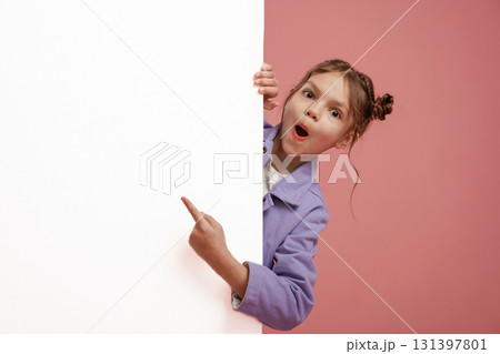 Showing at white copy space. Cute little girl is against pink background Showing at white copy space. Cute little girl is against pink background 131397801