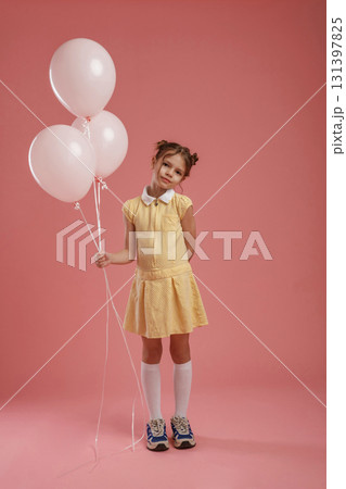 Bunch of balloons, party. Cute little girl is against pink background Bunch of balloons, party. Cute little girl is against pink background 131397825
