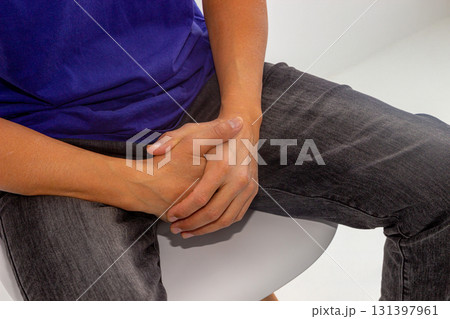 An adult man sits and appears to be covering his groin with his hands. Potency concept, impotence, male strength. urinary problems in men 131397961