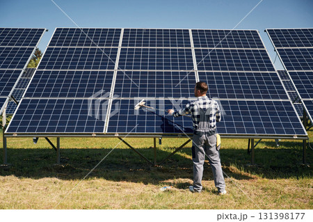 Surface must me clean. Engineer with photovoltaic solar panels outdoors at daytime Surface must me clean. Engineer with photovoltaic solar panels outdoors at daytime 131398177