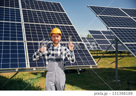 Traditional light bulb in hand. Engineer with photovoltaic solar panels outdoors at daytime 131398189