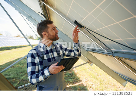 Under the photovoltaic solar panel and with digital tablet. Engineer outdoors at daytime 131398523