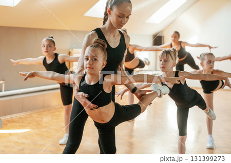 Athletic exercises together indoors. Group of female kids 131399273