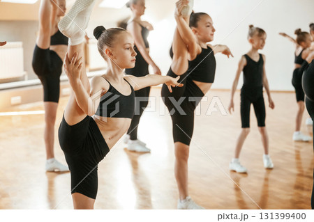 Aerobics conception. Group of female kids practicing athletic exercises together indoors Aerobics conception. Group of female kids practicing athletic exercises together indoors 131399400